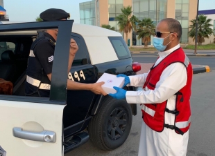 متطوعو الهلال الأحمر بالجوف يوزعون وجبات الإفطار على قائدي المركبات