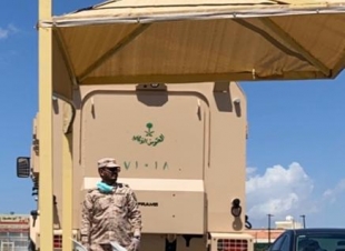 الروقي يوزع المضلات ليقي رجال الأمن من حرارة الشمس